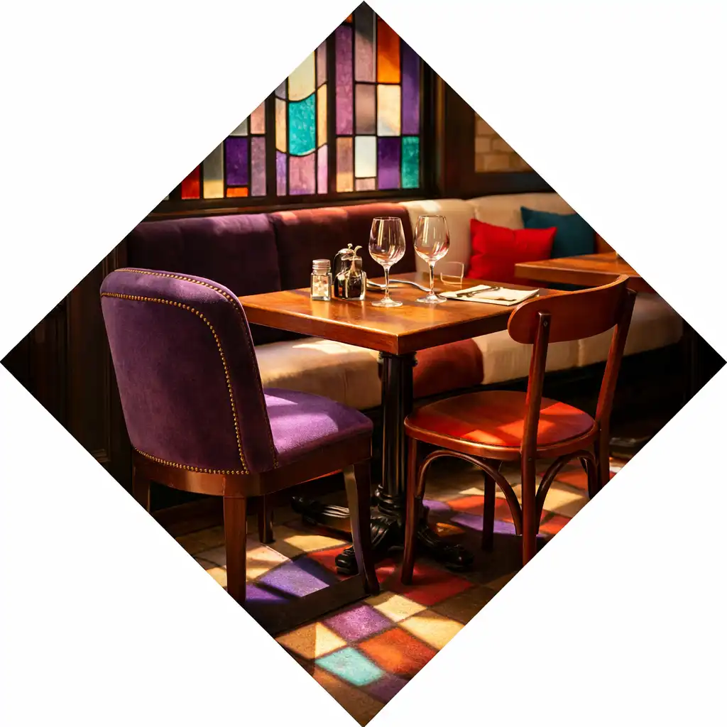 Intérieur du bistrot Comptoir Sureau avec verrières colorées style vitrail et tables en bois